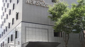 A hotel entrance with a sign reading 'HOTEL NEW SHIZUOKU'.