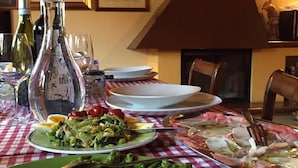 A dining table with plates of food, wine bottles, and glasses. - Cascina Baresane (Alba)