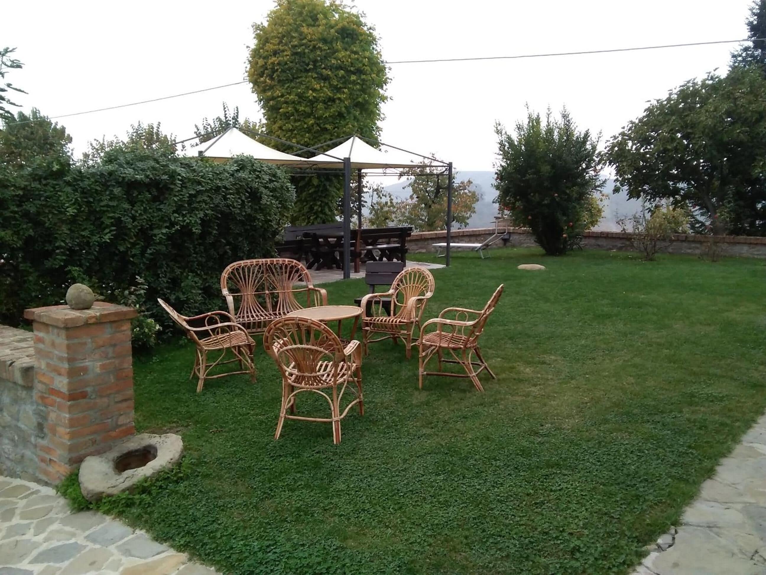 A patio area with wicker furniture, a brick wall, and a stone pathway.