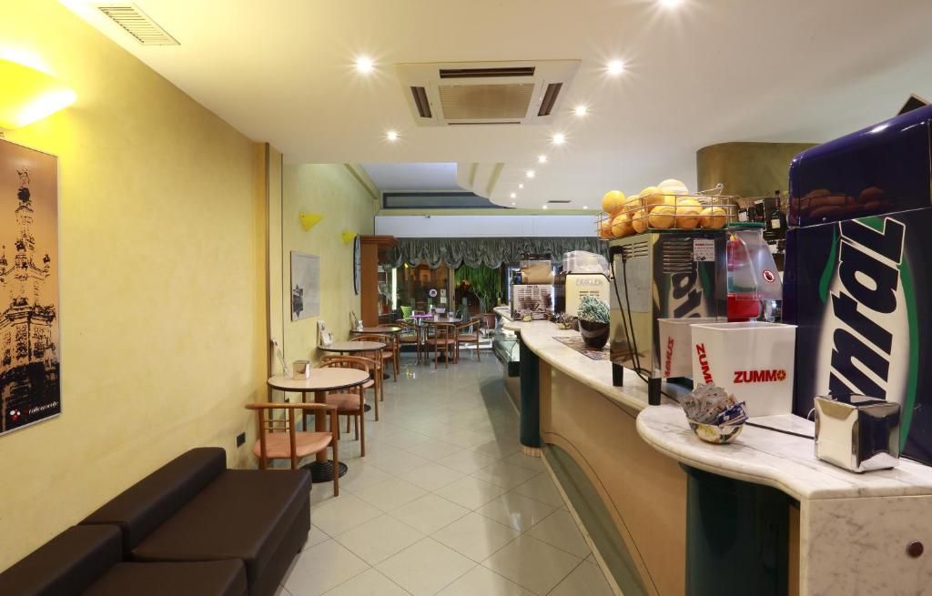 Interno di un ristorante con un bancone, zona salotto e vista sulla strada.