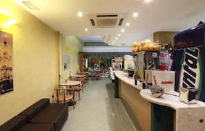 A restaurant interior with a counter, seating area, and a view of the street. - Cream & Caramel bed (Nardò)