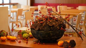 A dining area with a wooden table, a bowl of decorative items, and hanging pendant lights. - Hotel Garden Square Shizuoka (Shizuoka)