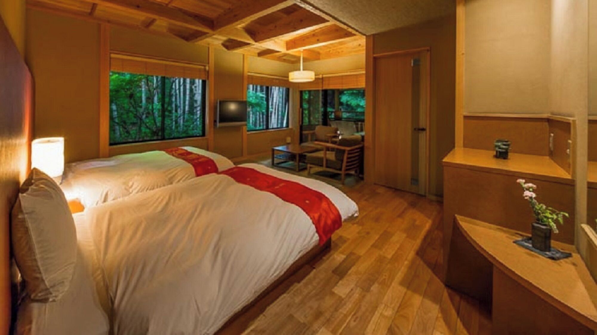 Une chambre avec deux lits, un bureau et une chaise, donnant sur les arbres par la fenêtre.