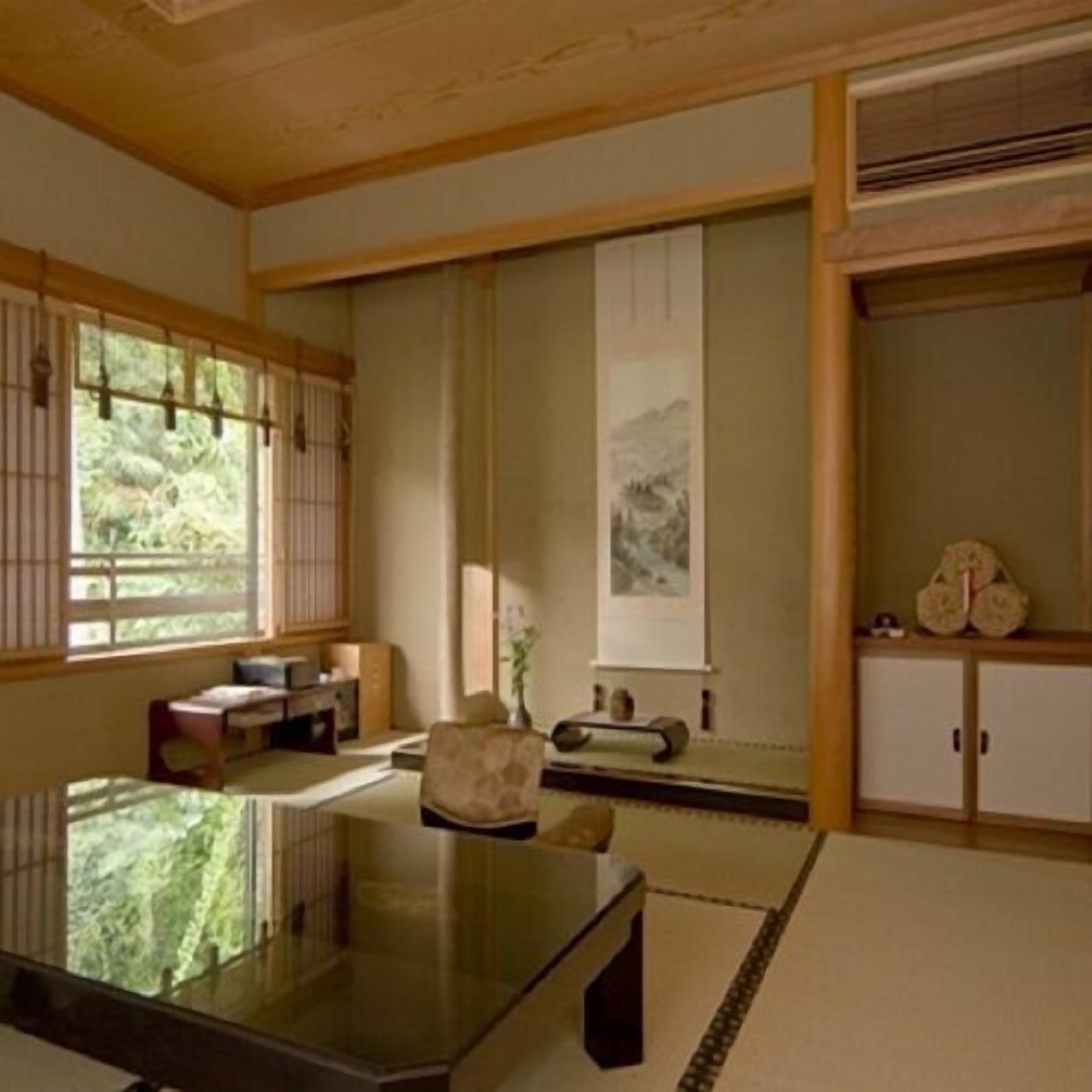 A traditional Japanese room with tatami flooring, a low table, a cushioned chair, a sliding door, and a wall-mounted cabinet.
