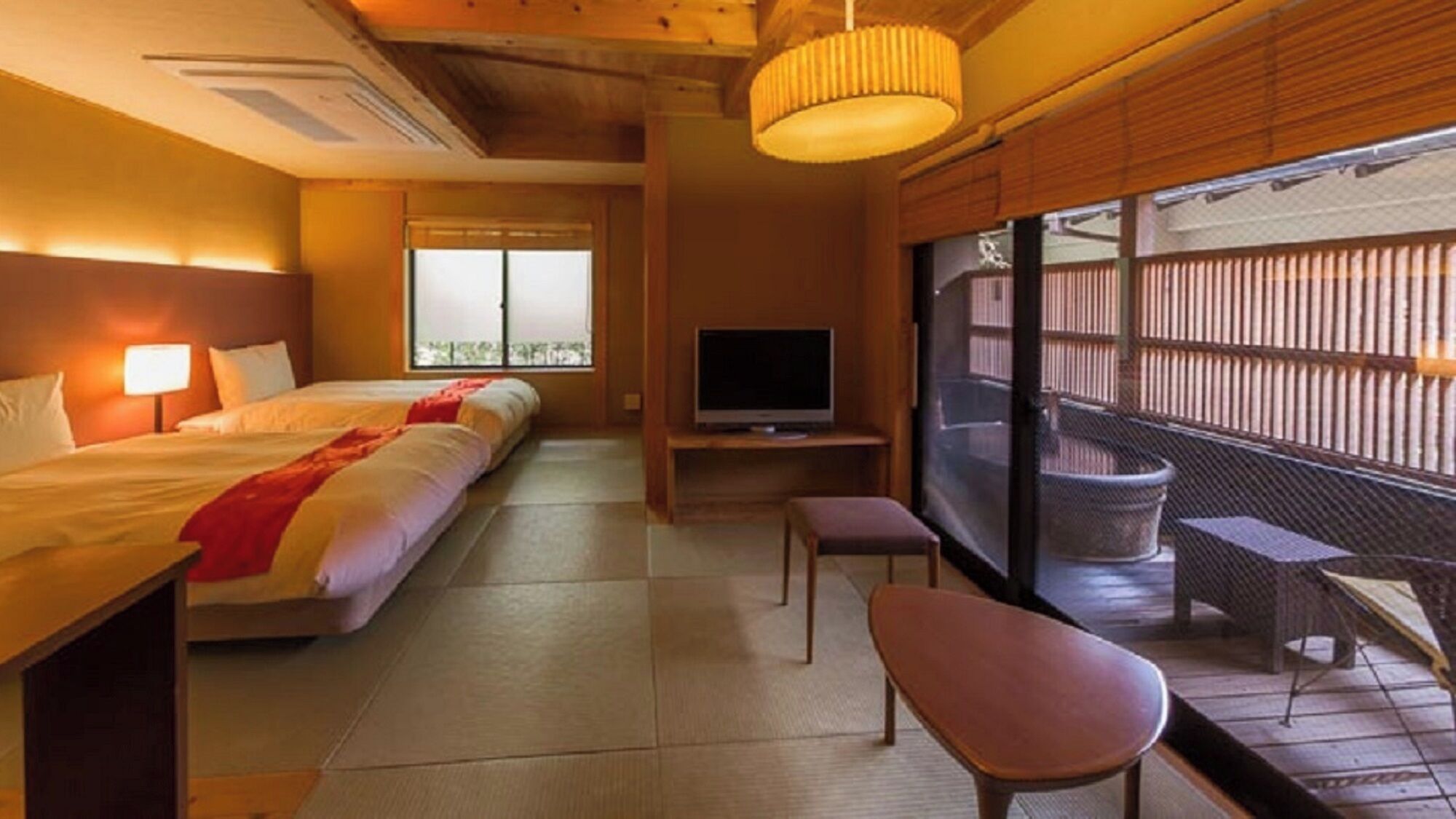 Une chambre d’hôtel avec un lit, une télévision, un balcon avec vue et un plafond en bois.