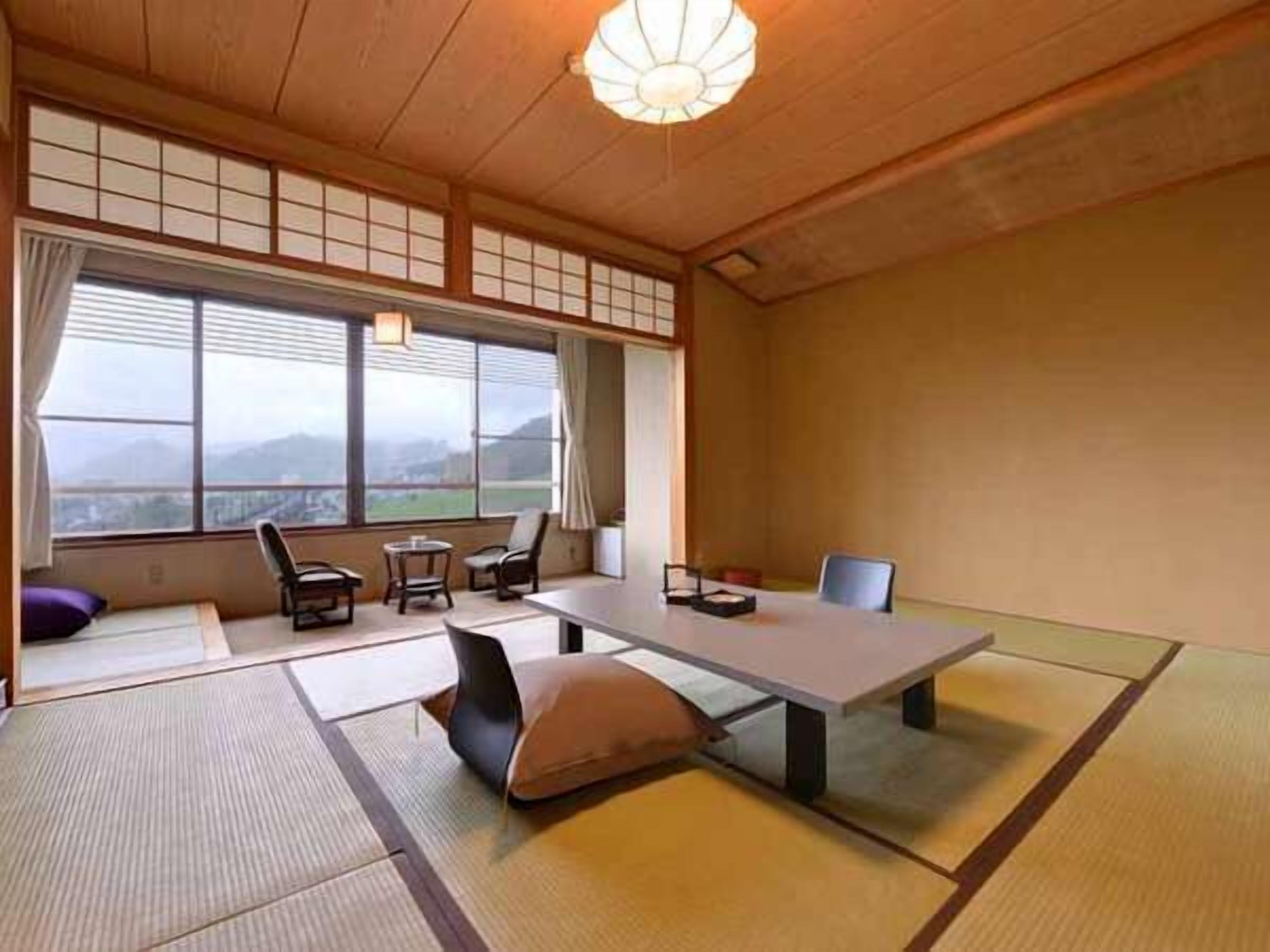 Ein traditioneller japanischer Raum mit Tatami-Boden, einem niedrigen Tisch und Stühlen.
