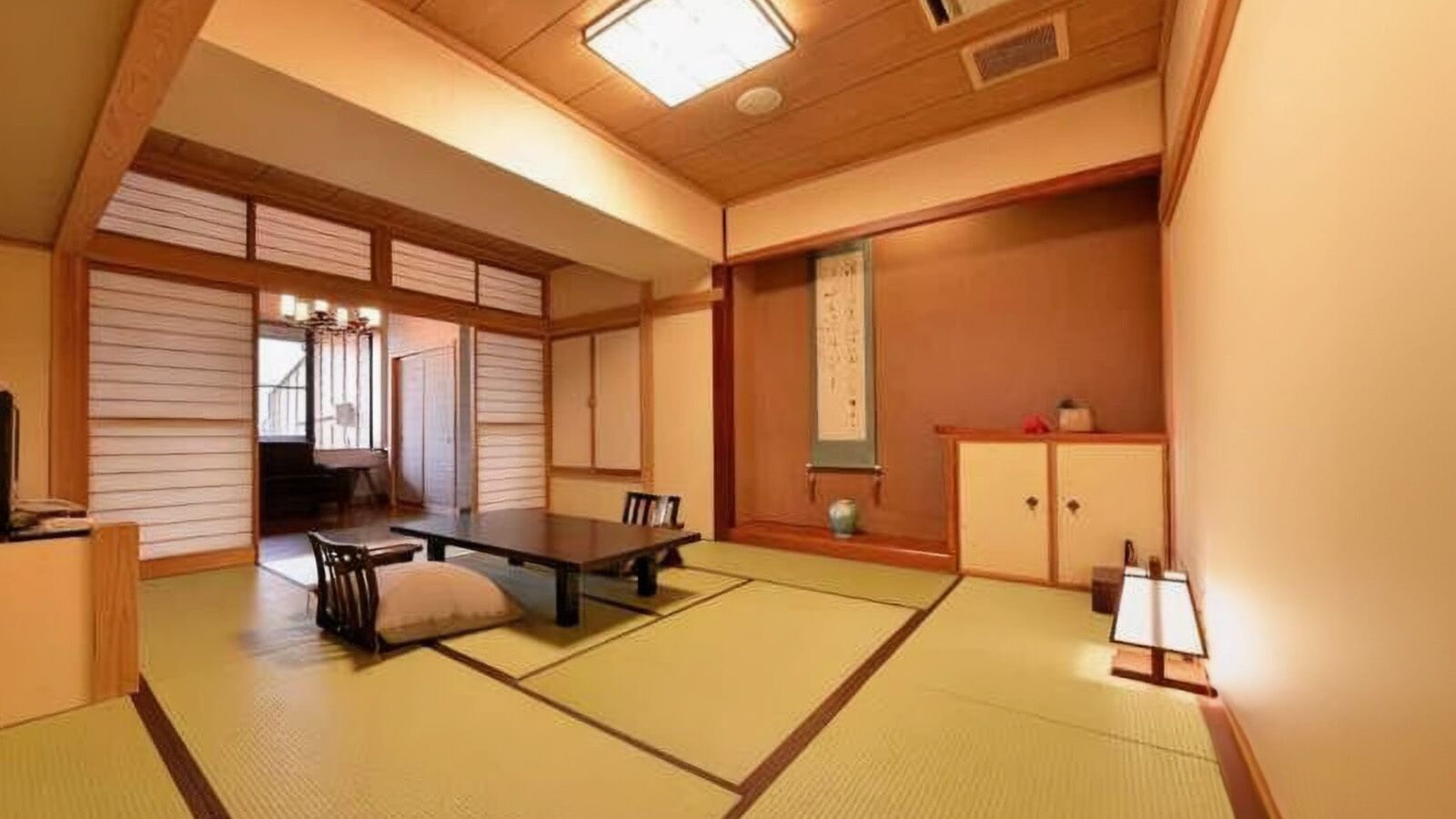 Ein traditioneller japanischer Raum mit Tatami-Böden, einem niedrigen Tisch und Schiebetüren.