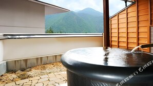 A hot tub with a view of mountains, a wooden wall, and a tiled floor. - Echigoyuzawa Onsen Ichibousenri Onyuyado Nakaya (Yuzawa)