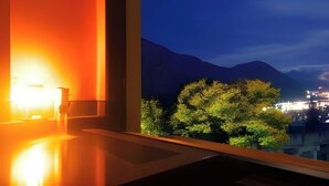 A room with a large window overlooking a mountainous landscape at night. - Echigoyuzawa Onsen Ichibousenri Onyuyado Nakaya (Yuzawa)