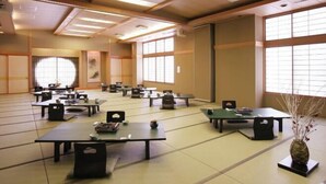 Ein traditioneller japanischer Raum mit Tatami-Matten, niedrigen Tischen und Schiebetüren.