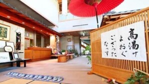 Ein traditionelles japanisches Interieur mit Tatami-Matten, einem Empfangsschalter und einem roten Regenschirm.