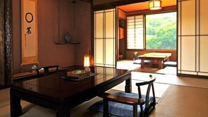 A traditional Japanese room with tatami flooring, a low table, and sliding doors. - Shikinosato Kikuya (Sekikawa)