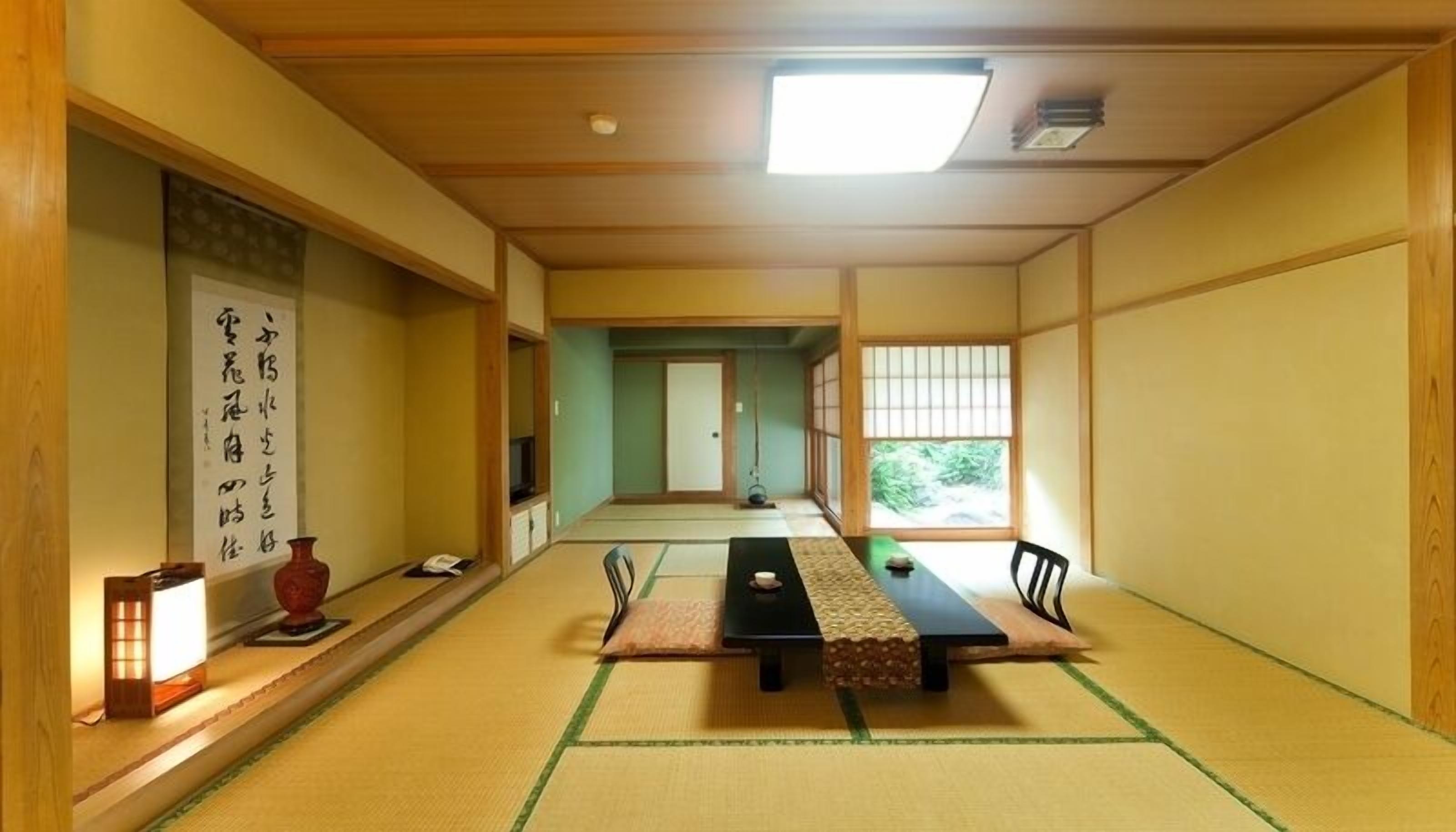 A traditional Japanese room with tatami flooring, a low table, and sliding doors.