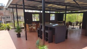 An outdoor patio with a covered seating area, a bar, and potted plants. - Hibiscus Tabua Villas (Nadi)