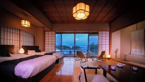 Quarto de hotel com duas camas, varanda e vista, e decoração japonesa tradicional.