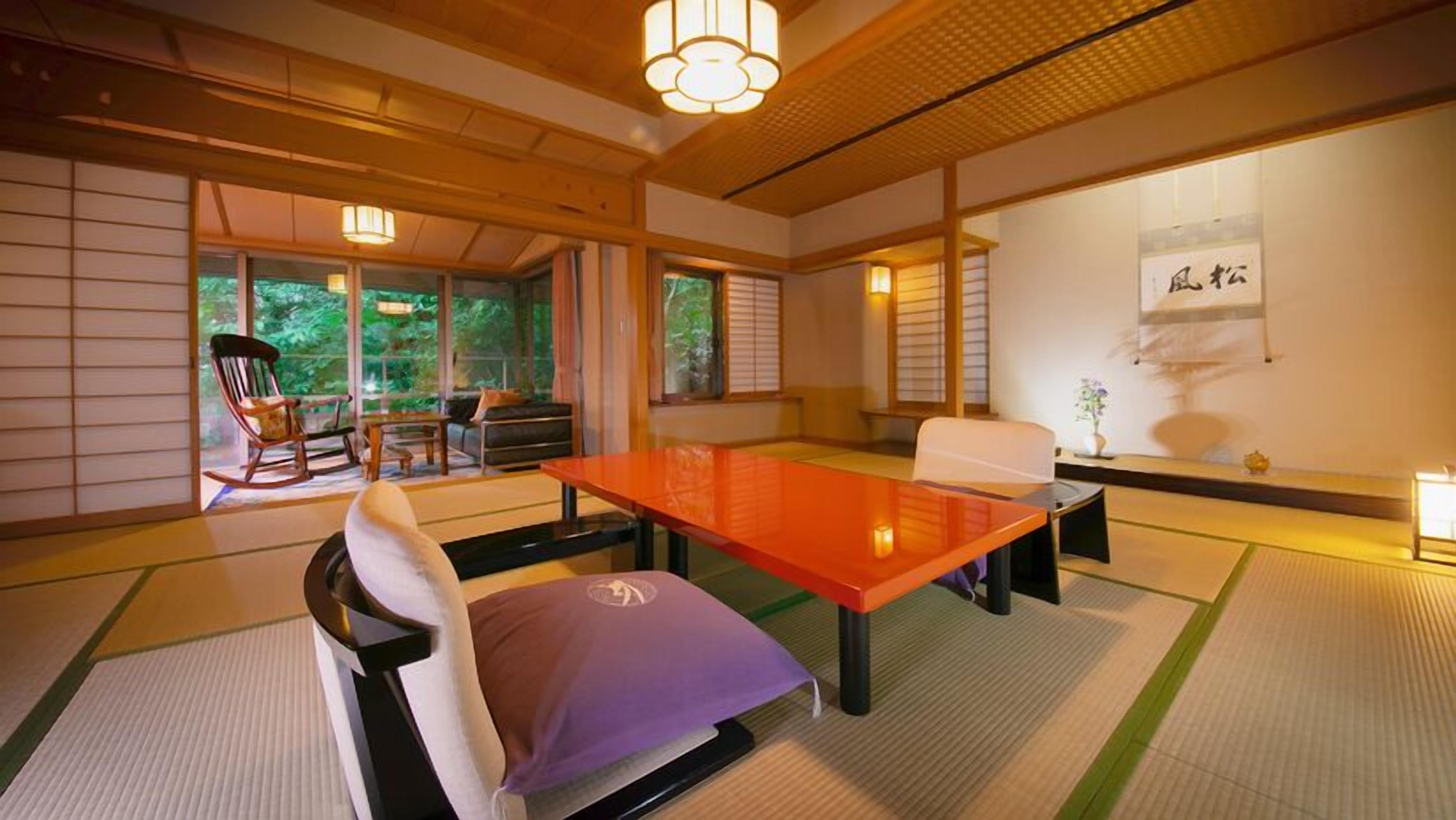 A traditional Japanese-style room with tatami flooring, a low table, and a sofa.