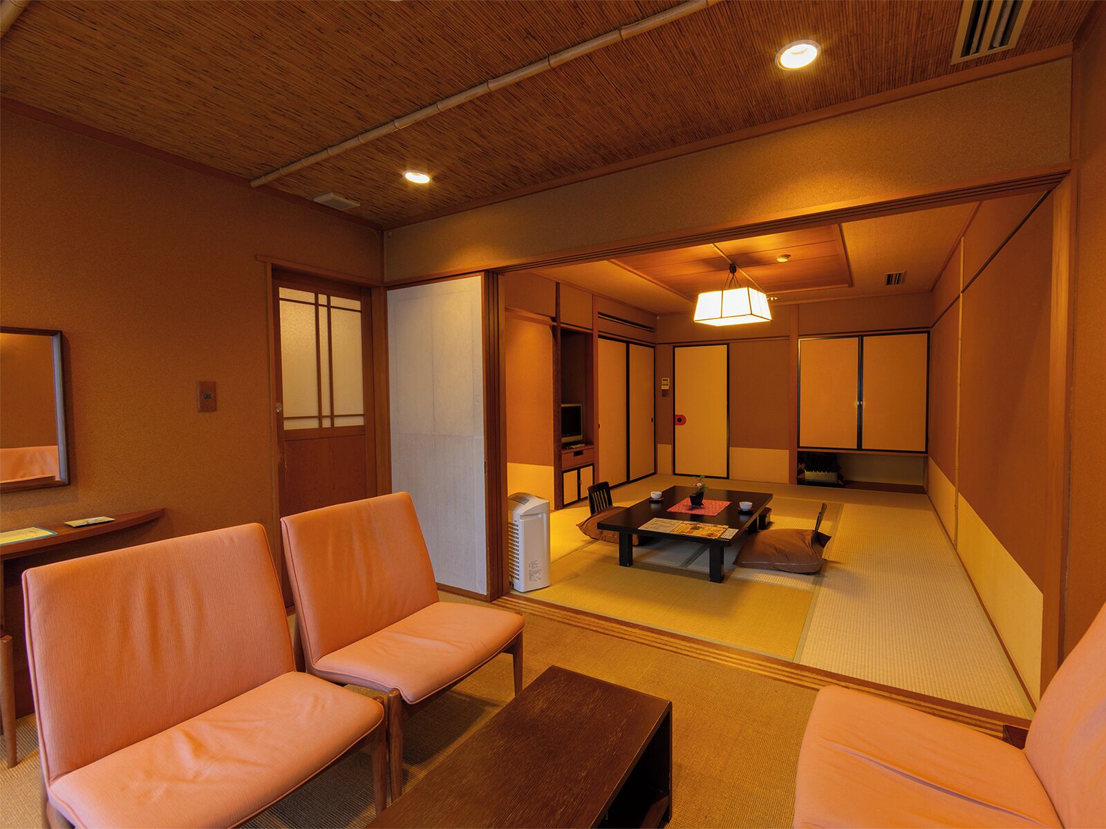 A traditional Japanese-style room with tatami flooring, low tables, and sliding doors.