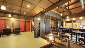 Una habitación tradicional japonesa con suelo de tatami, muebles de madera y una mesa baja con un farol.