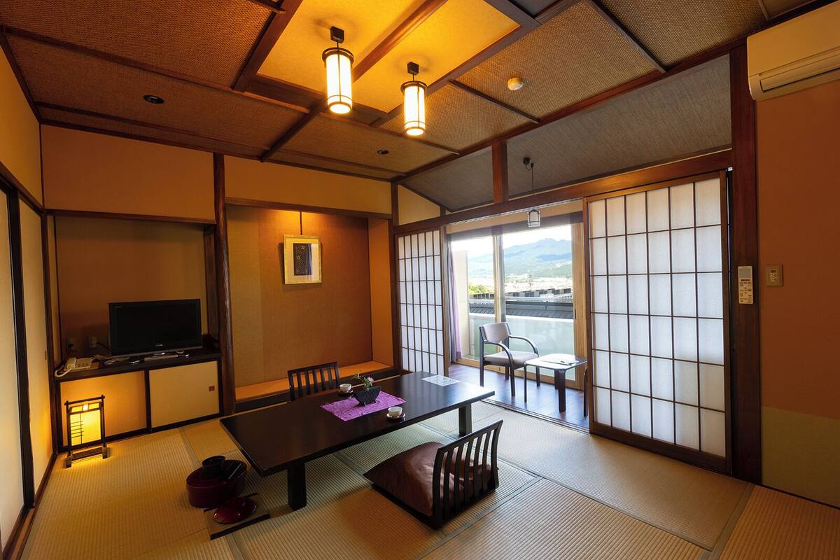 A traditional Japanese room with tatami flooring, a low table, and sliding doors.