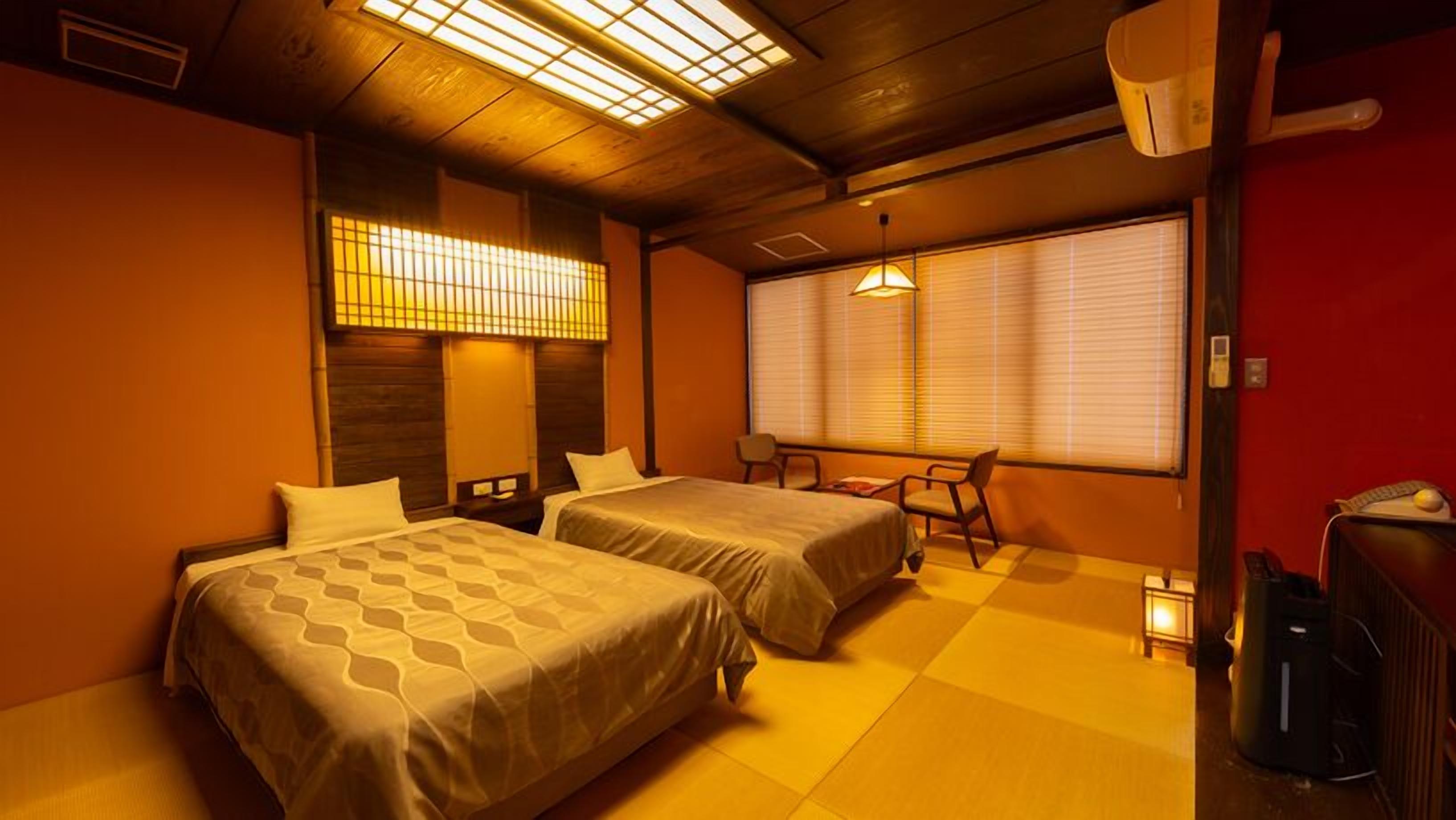 Une chambre d’hôtel avec deux lits, un bureau et une chaise.