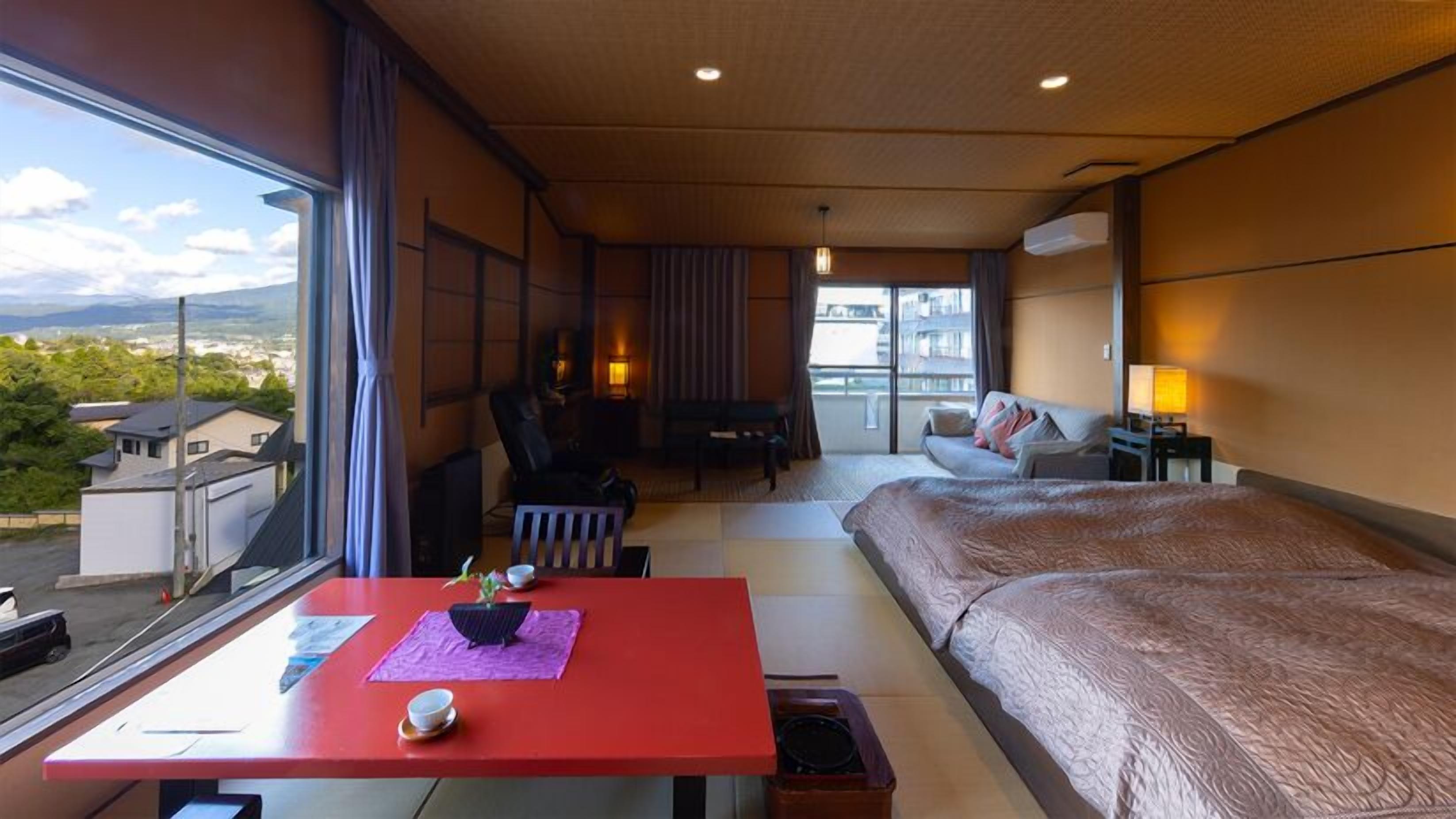 Une chambre d’hôtel avec un lit, un bureau, une chaise, un canapé et une vue sur la ville.