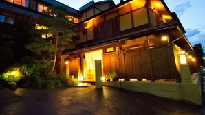 Un edificio tradicional japonés con fachada de madera y una entrada bien iluminada.