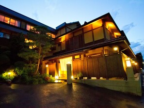 Vista frontal de la propiedad por la tarde o noche