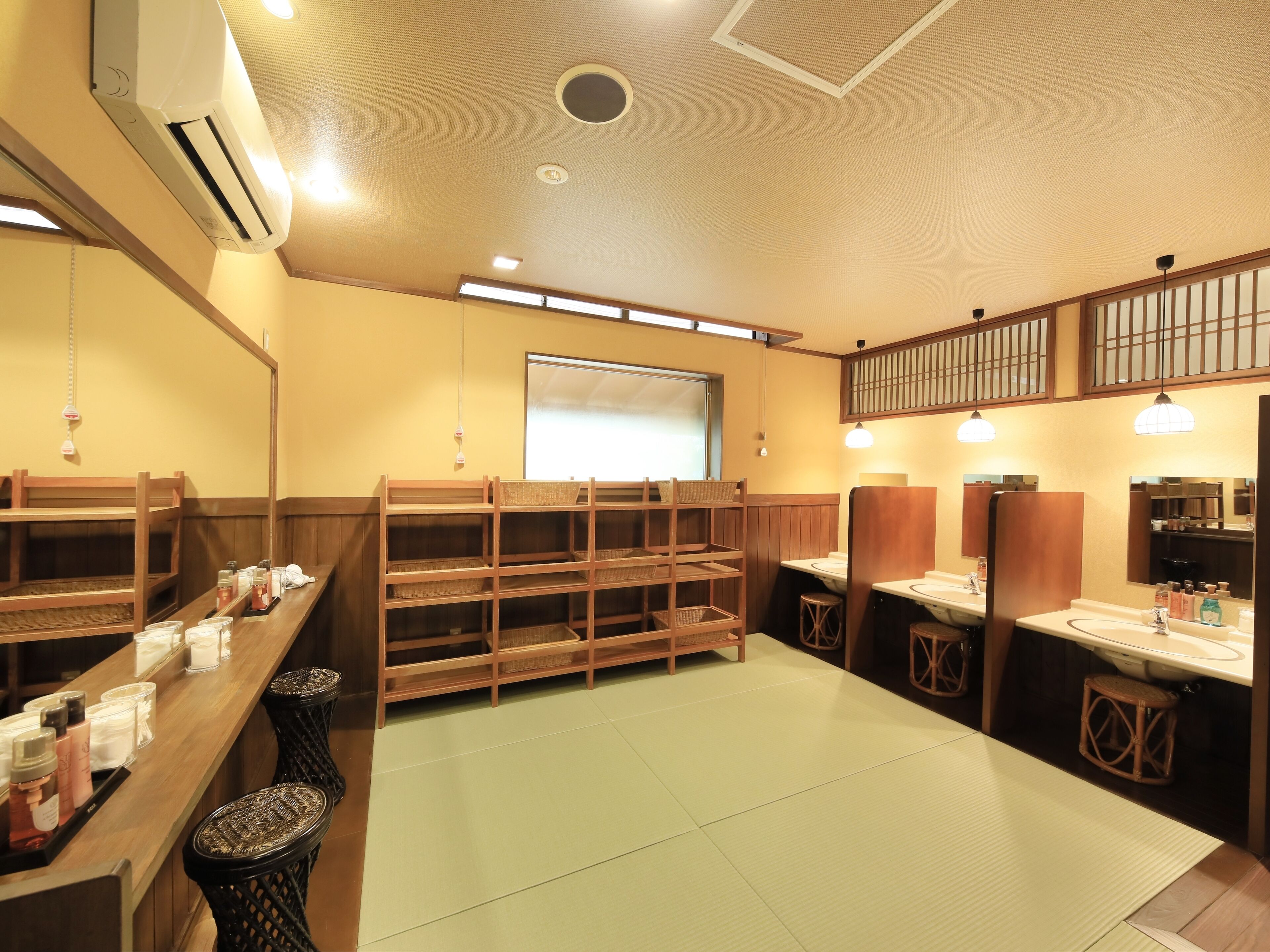 A traditional Japanese-style room with tatami flooring, wooden furniture, and a large mirror.