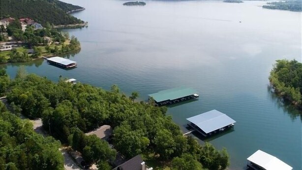 A lake with several floating structures, surrounded by dense greenery and distant hills. - Happy Hideaway 4 Bedroom Home by RedAwning (Blue Eye)