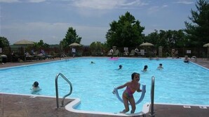 A swimming pool with multiple lanes, surrounded by lounge chairs and umbrellas. - Gorgeous Greens 2 Bedroom Condo by RedAwning (Branson)
