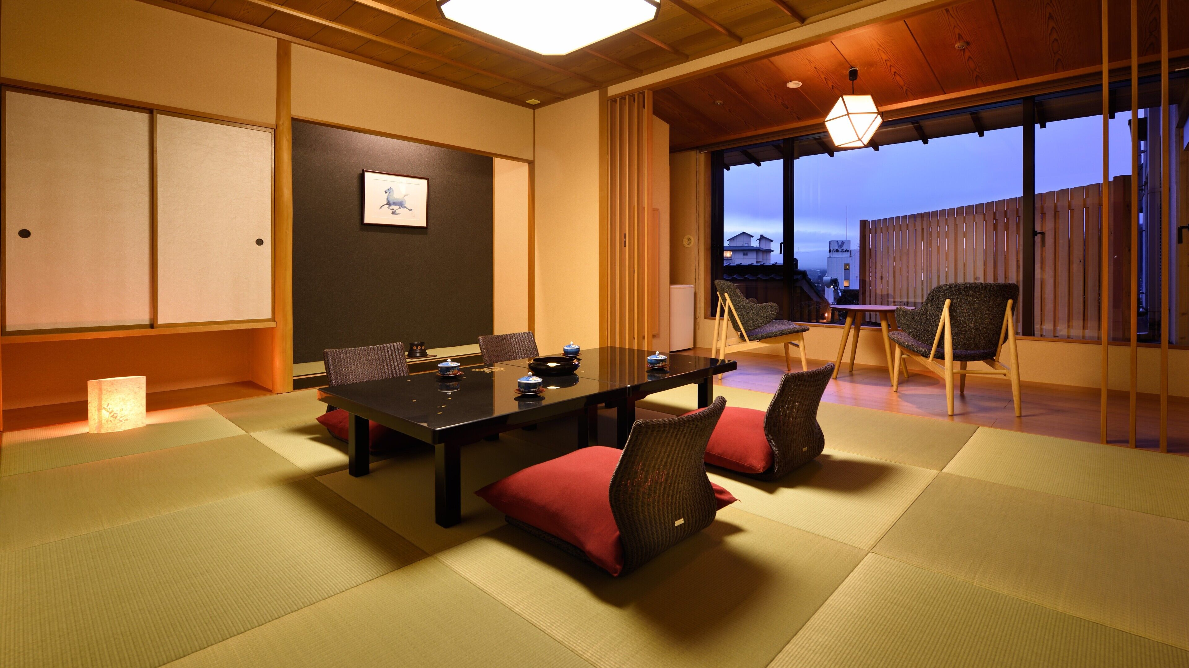 Ein traditioneller japanischer Raum mit Tatami-Böden, einem niedrigen Tisch und Stühlen.
