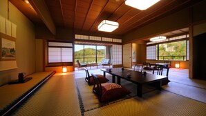 Een traditionele Japanse kamer met tatami vloerbedekking, een lage tafel, stoelen en schuifdeuren.