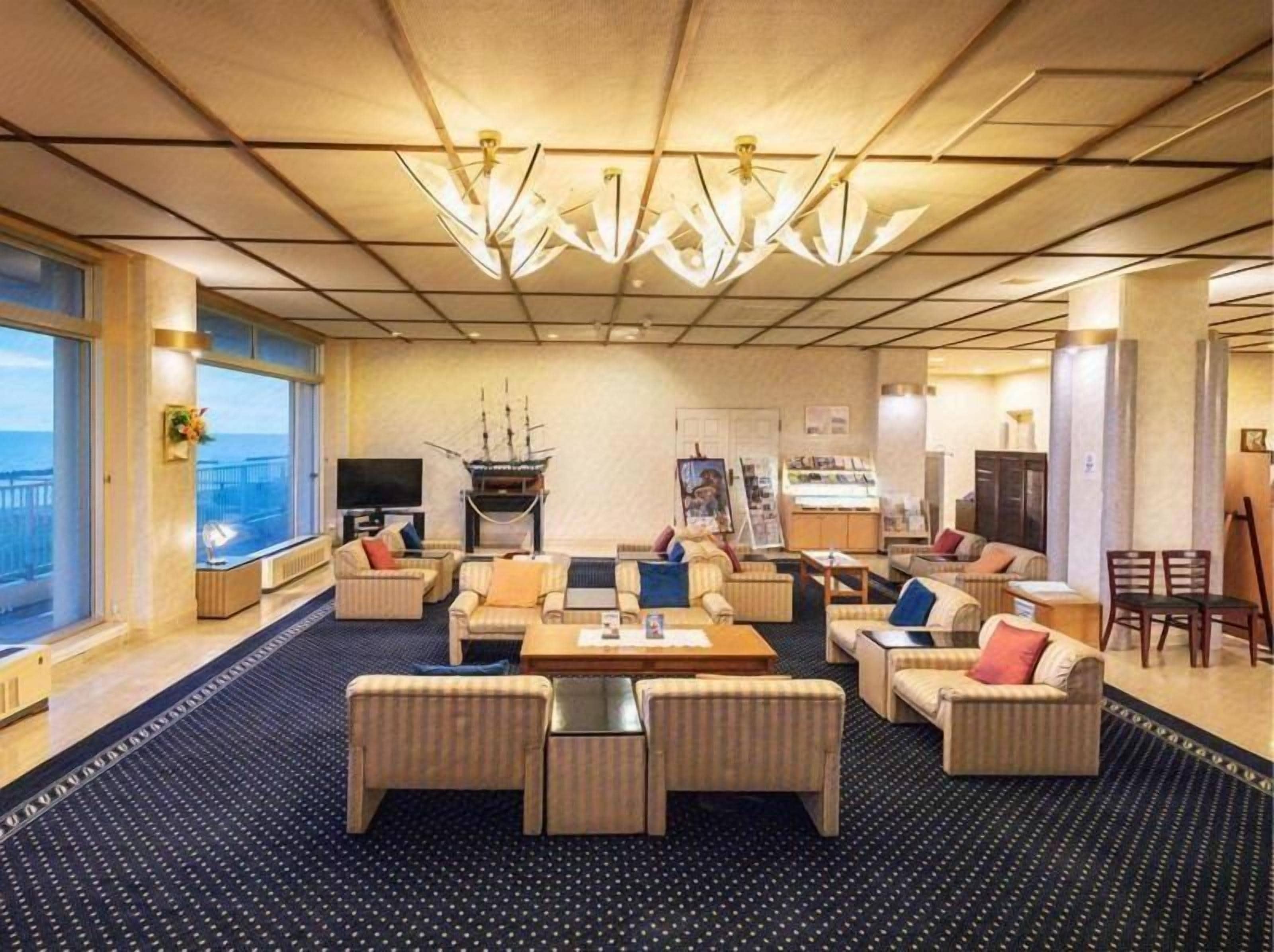 Een ruime hotelbar met een grote zithoek, een open haard en uitzicht op zee.