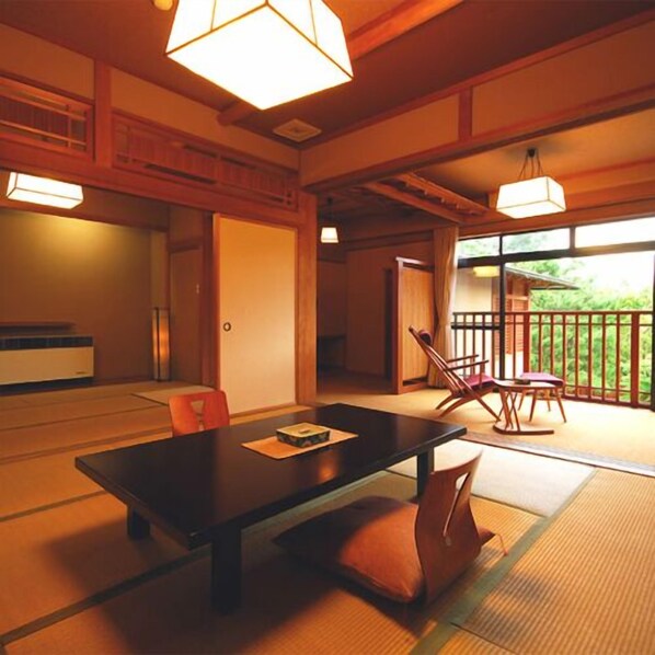 A traditional Japanese room with tatami flooring, a low table, and chairs.