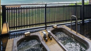 Ett spaområde med två bubbelpooler och utsikt över havet.