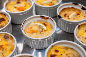 A close-up of several ramekins containing a creamy dish, possibly a crème brûlée, with a caramelized top. - Richmond Hotel Sendai (Sendai)