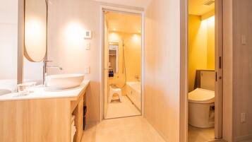A modern bathroom with a large mirror, a sink, and a toilet.