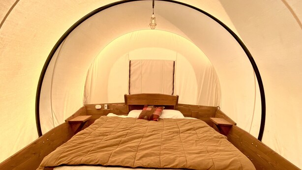 A single bed in a tent-like room with a wooden floor and a simple headboard. - Buffalo Valley Ranch (Moran)