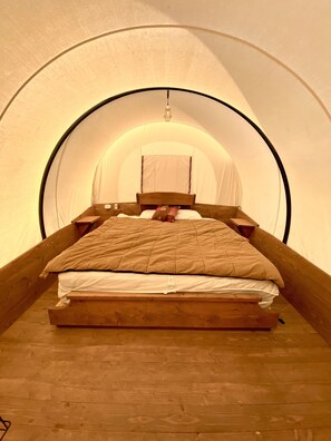 A single bed in a tent-like room with a wooden floor and a simple headboard. - Buffalo Valley Ranch (Moran)