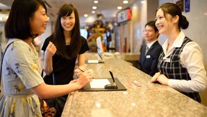 A reception area with a marble counter, a name tag, and a pen on a notepad. - Sun Marine Kesennuma Hotel Kanyo (Kesennuma)