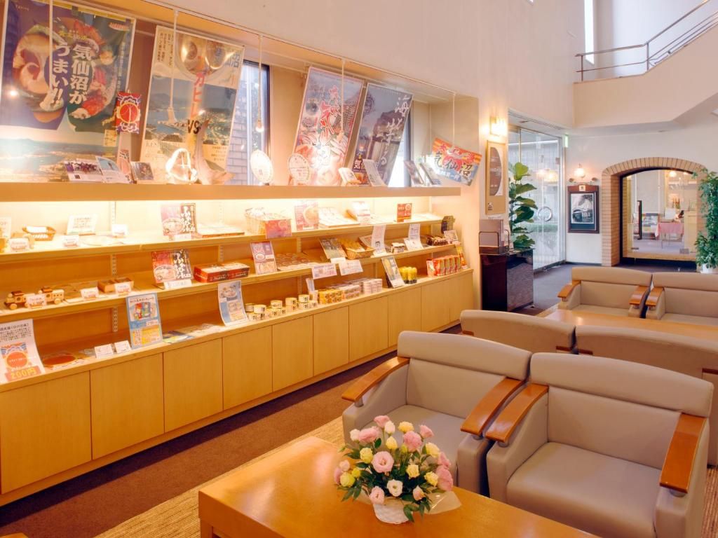 A hotel lobby with a reception desk, seating area, and a display of magazines and books.