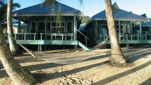 A beachfront property with multiple overwater bungalows featuring balconies and a sandy beach area. - Sunhaven Beach Bungalows (Rarotonga)