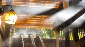 A wooden structure with a hanging light fixture and a water feature. - Nishiya (Yonezawa)