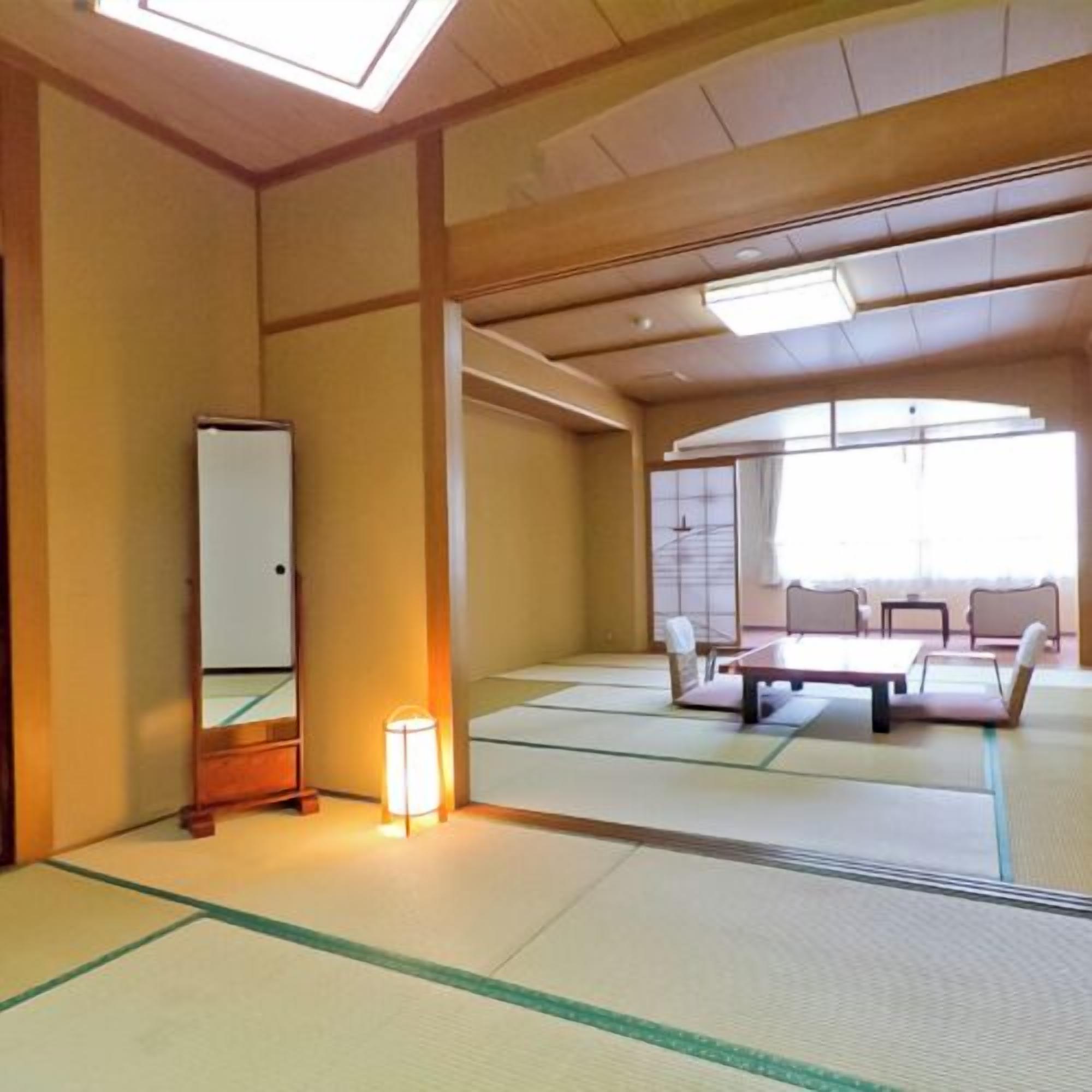 A tatami mat room with a bed, a mirror, and a lamp.