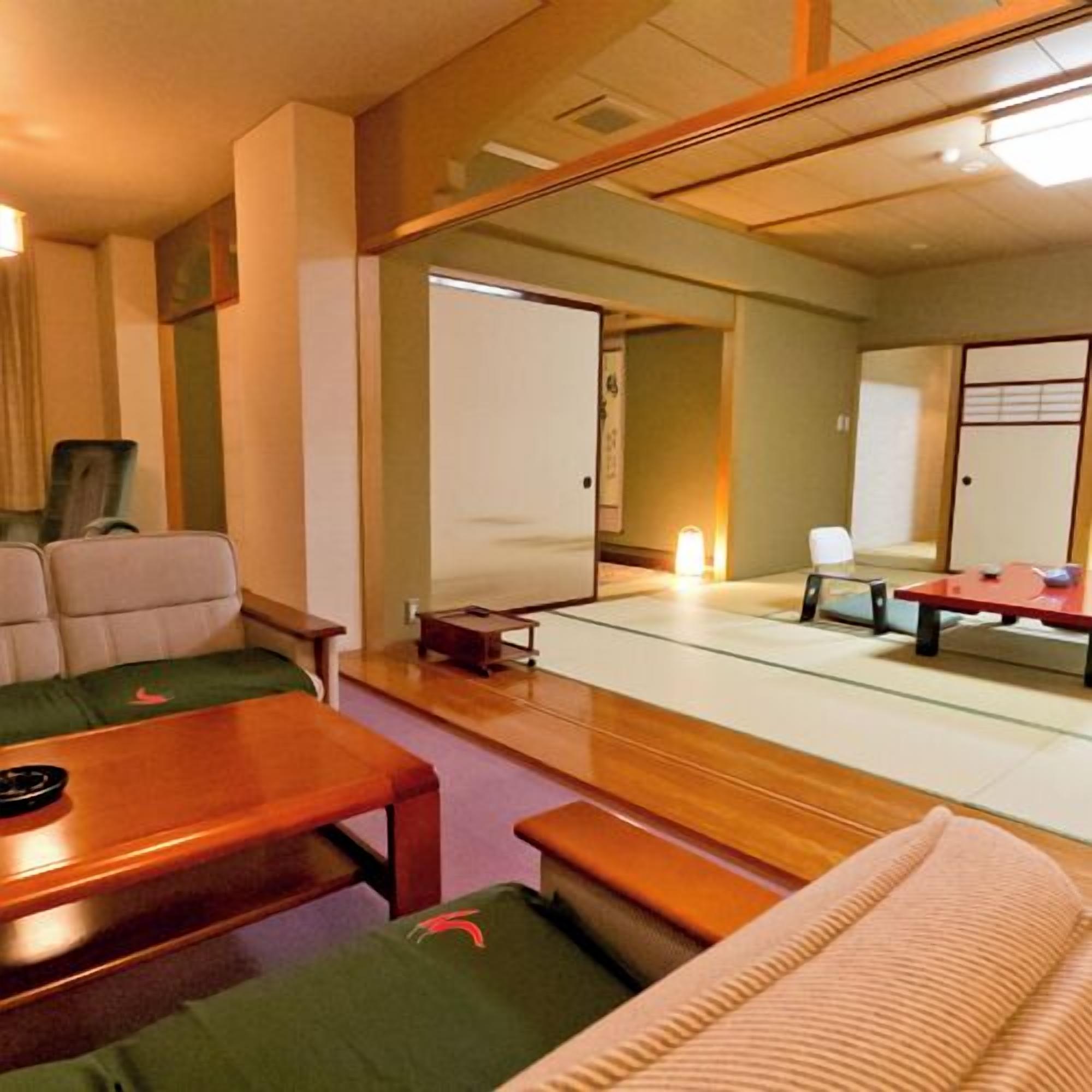 A traditional Japanese room with tatami flooring, a low wooden table, and a futon bed.