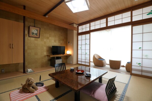 A traditional Japanese-style room with tatami flooring, a low table, and shoji screens.