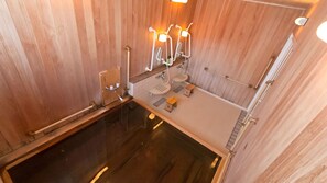 Un sauna en bois doté d’un plancher en verre, de deux lavabos et d’un porte-serviettes.