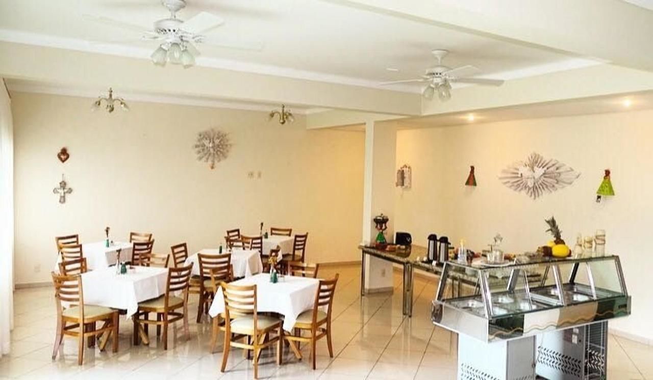 A dining area with multiple tables and chairs, a buffet station, and ceiling fans.