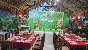 An outdoor dining area with tables set for a meal, surrounded by wooden chairs. - Dong Que Homestay-Tours-Motorbike, Car rental, Hiking (Ha Giang 1)