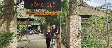 A stone archway with signs for a homestay and restaurant.